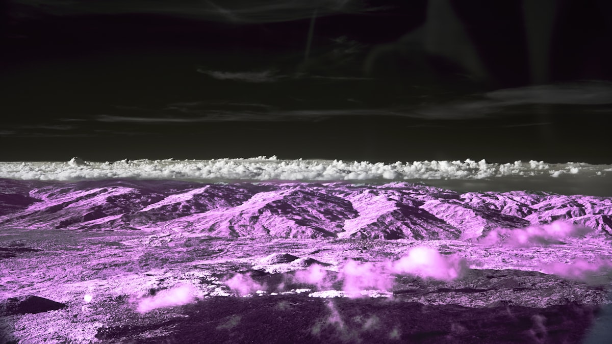Pink mountains under a dark, cloudy sky