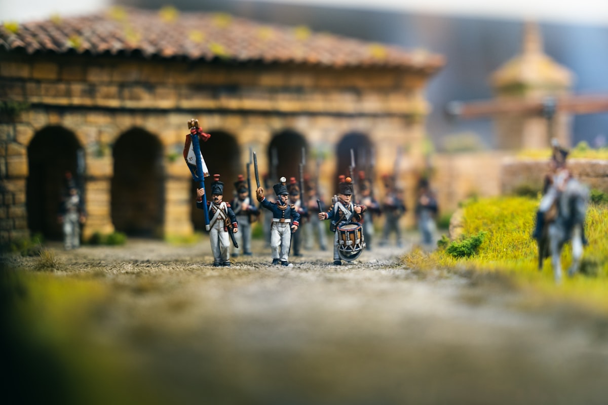Miniature soldiers in uniform marching with flags.