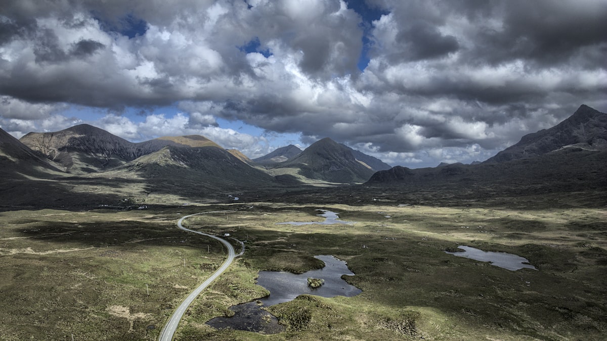 Mountains and winding road under a dramatic sky