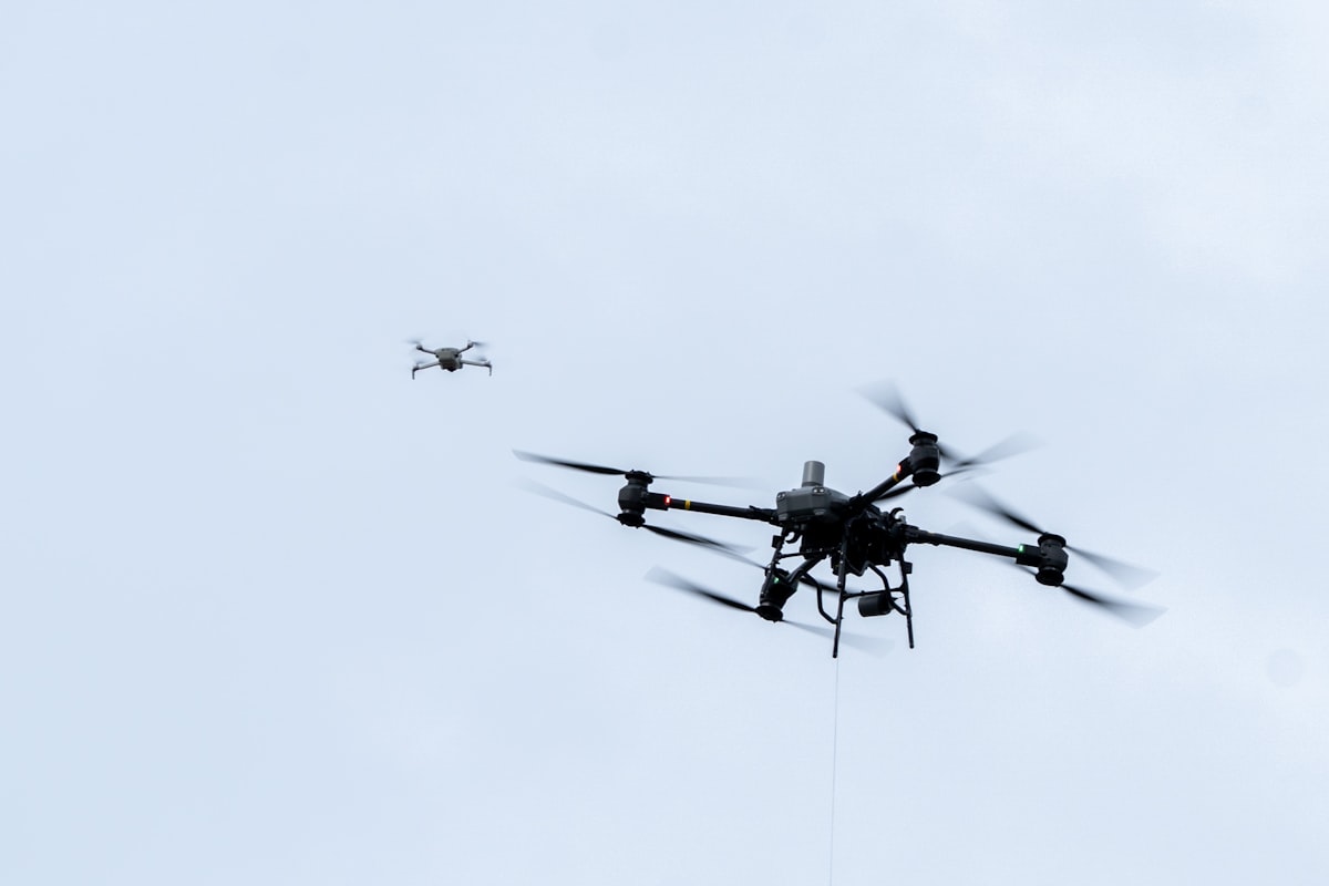 Drones are flying in a cloudy, blue sky.