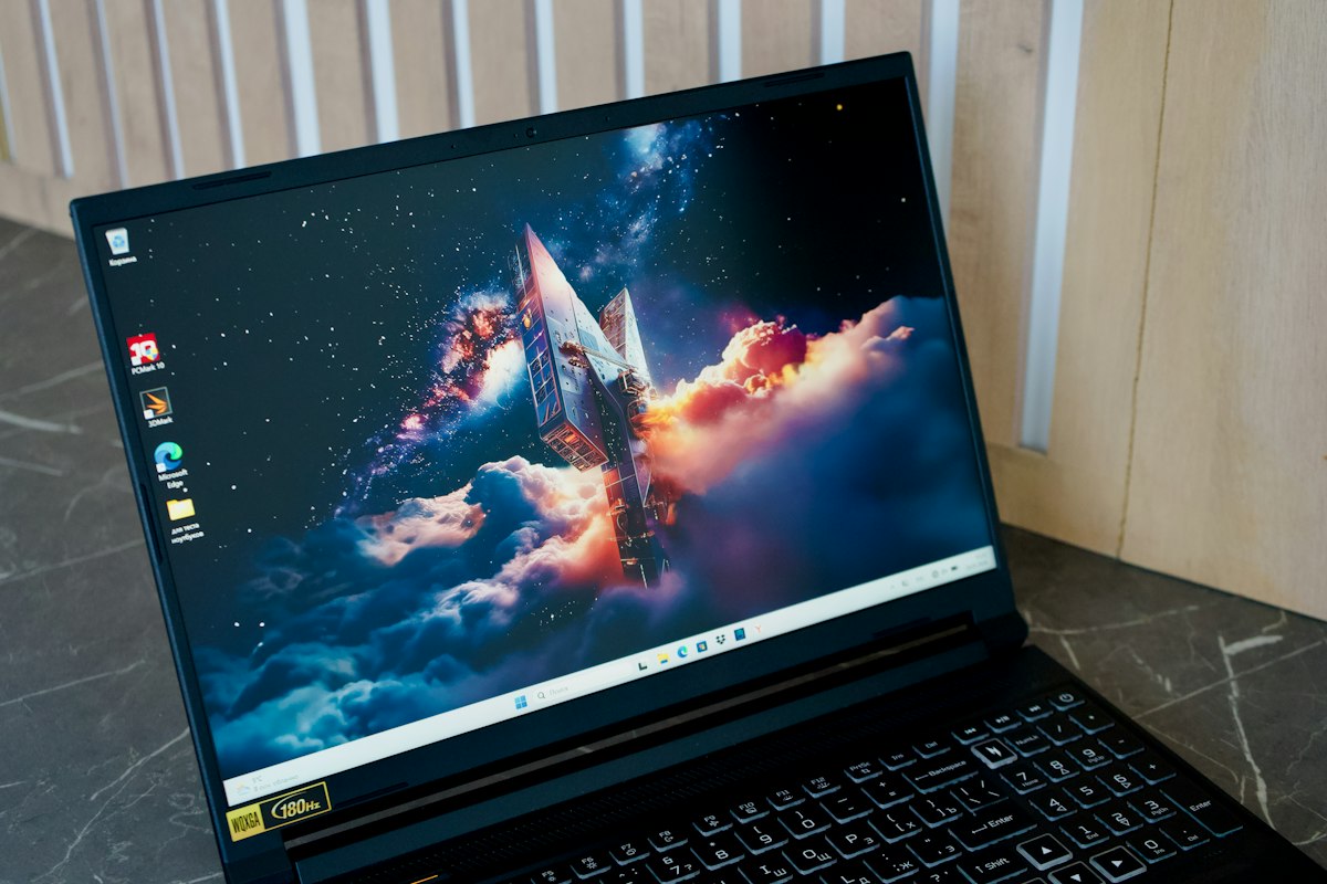 A black laptop displaying a space rocket wallpaper