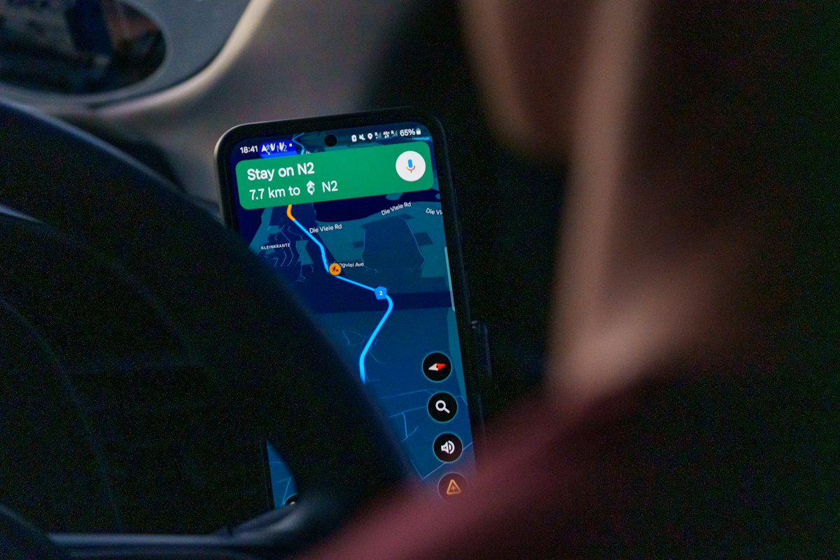 Person using navigation app on smartphone inside car
