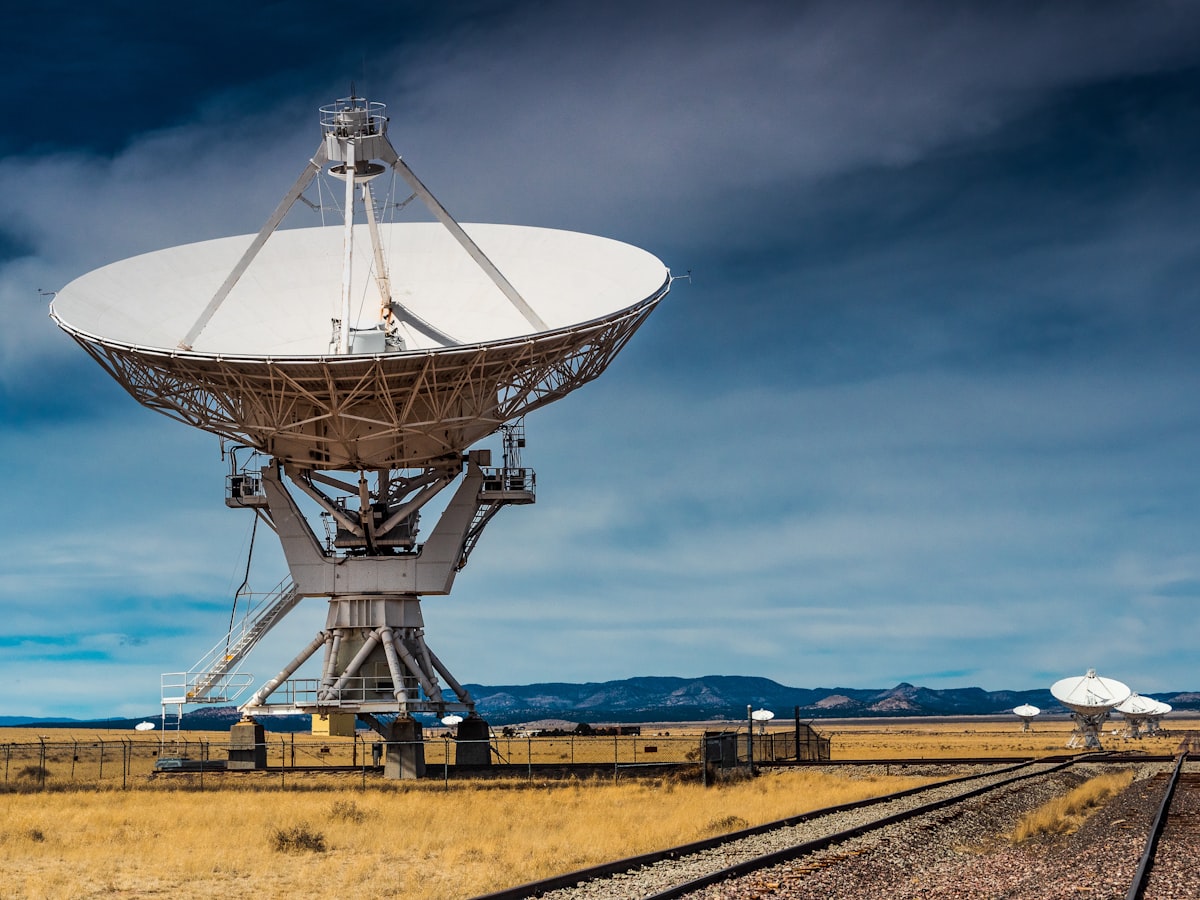 a very large satellite dish sitting on top of a train track