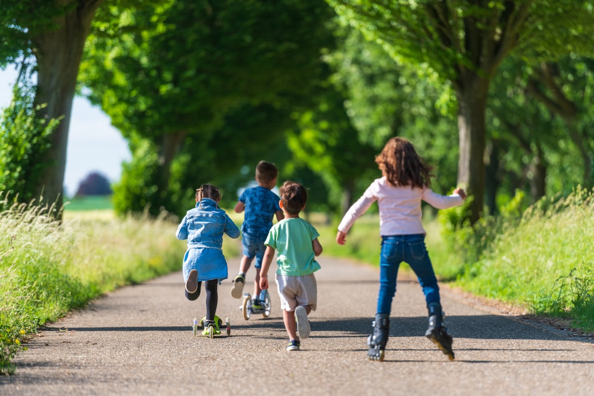 a group of kids rollerblading down a road
