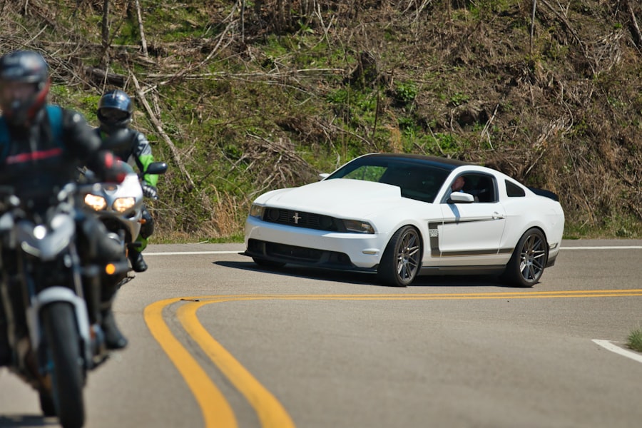 White sports car and motorcycles on a winding road