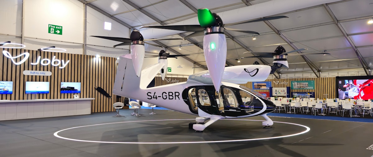 White electric aircraft with rotors on display indoors