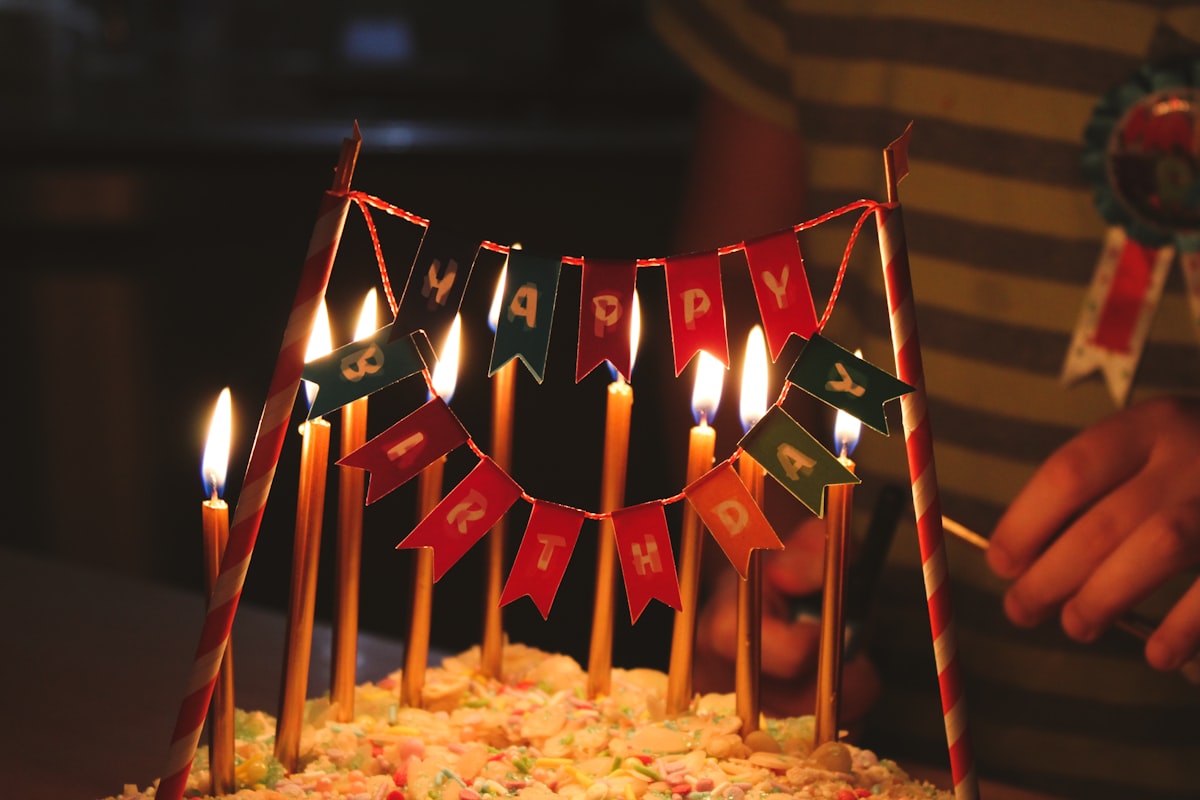 A birthday cake with candles and flags on it