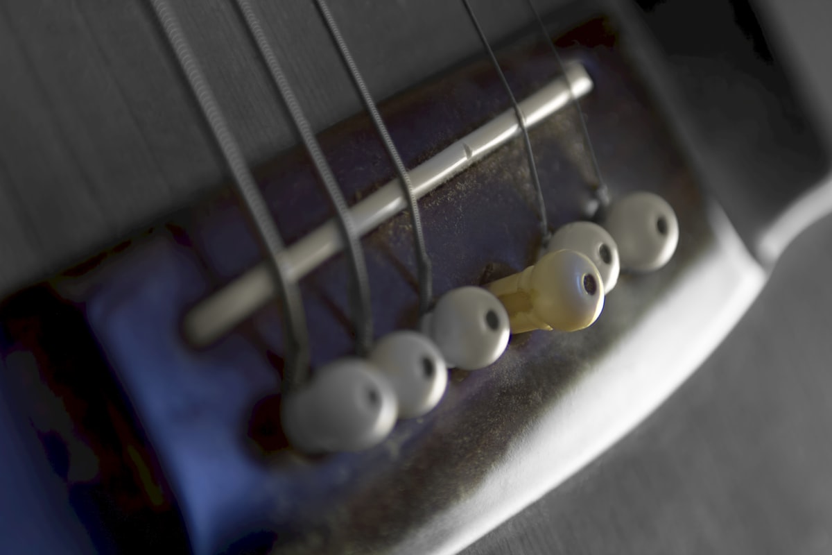 Close-up of acoustic guitar bridge and strings.