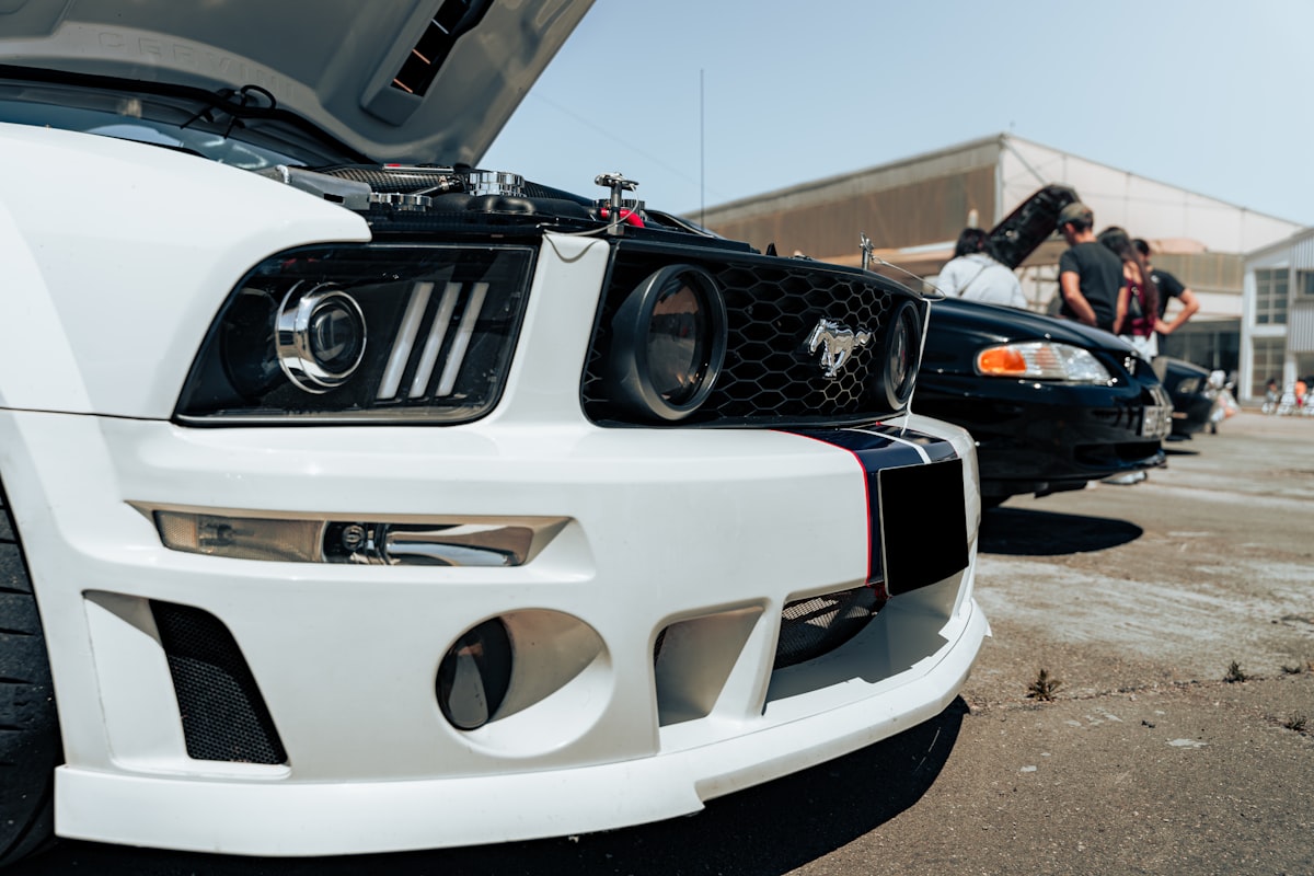 A close up of the hood of a white mustang