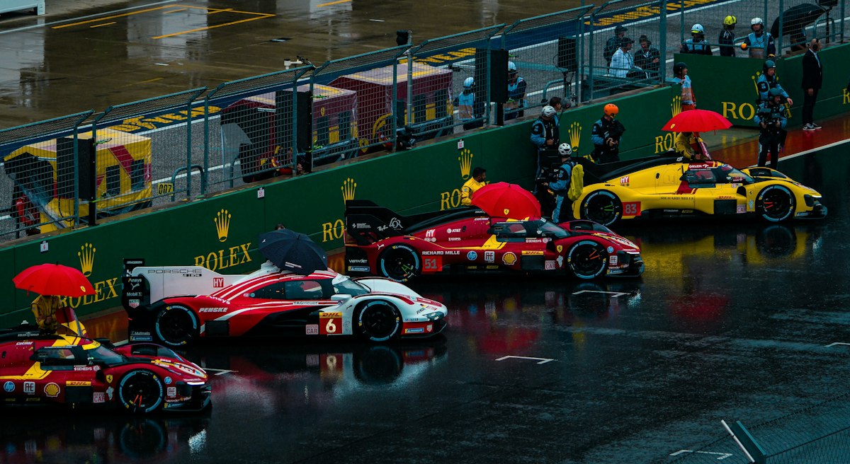 Race cars with umbrellas in the rain