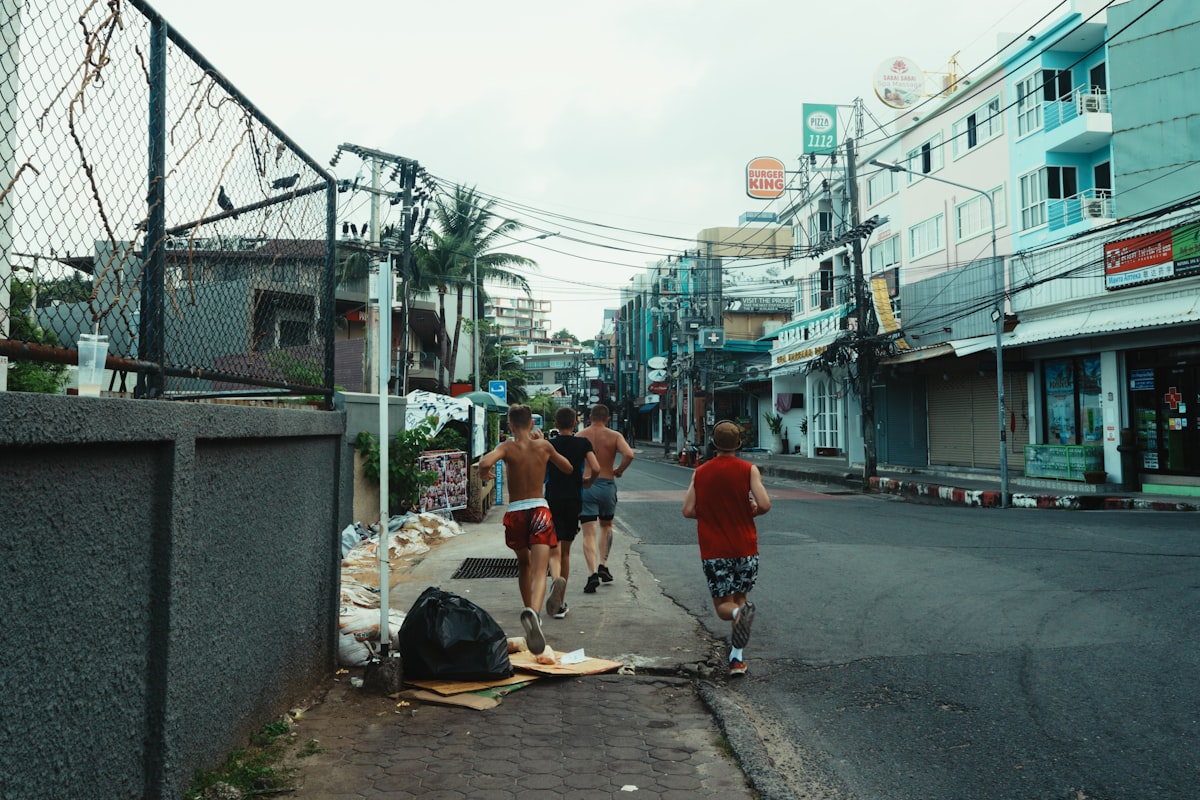 Three young men running down a street