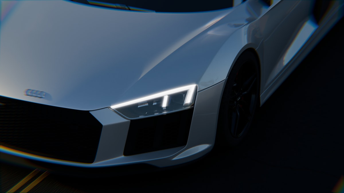 Close-up of a sleek white sports car headlight.