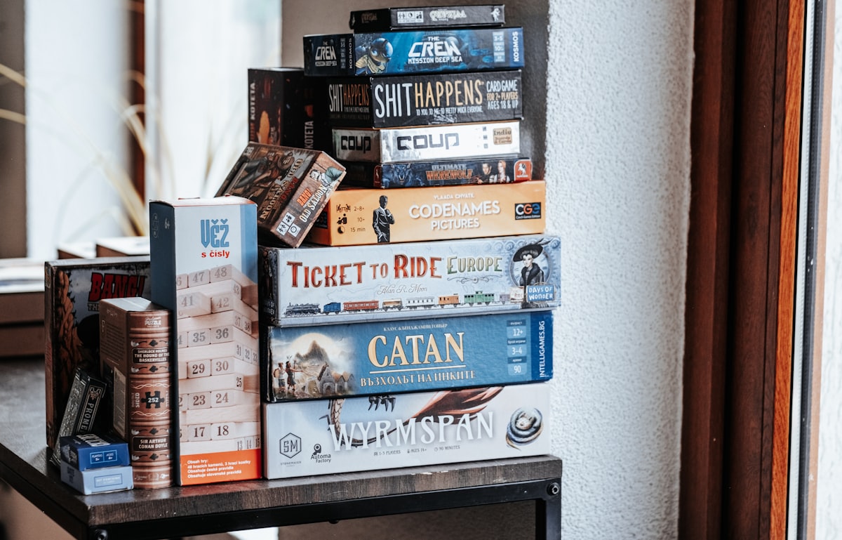Board games are stacked on a shelf