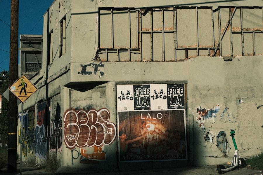 Graffiti-covered building with posters and scooter.