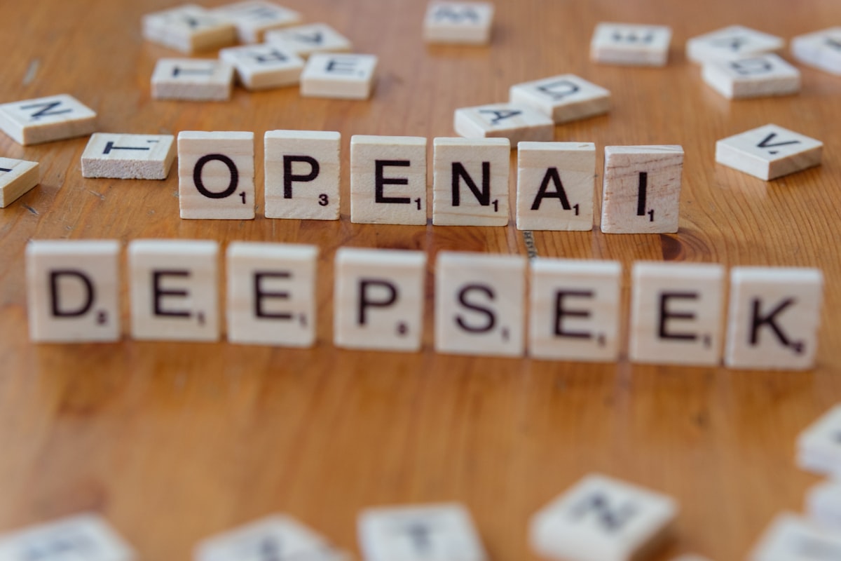 A wooden table topped with scrabble tiles spelling open and deep seek