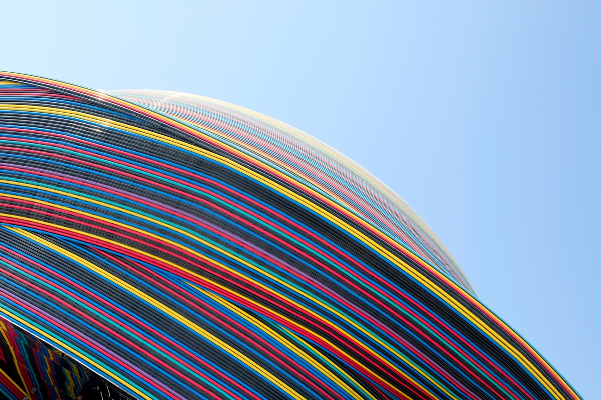 a close up of a multicolored umbrella against a blue sky