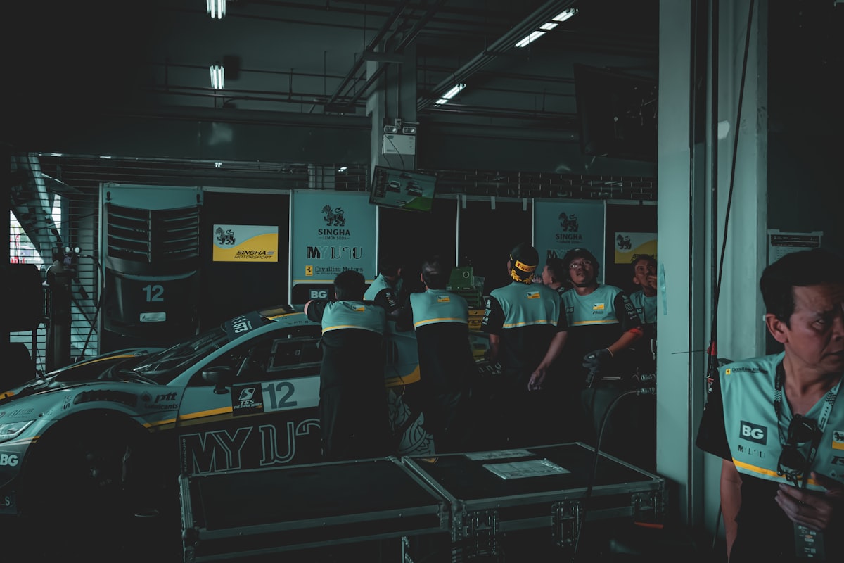 Race car and crew in a dimly lit garage.