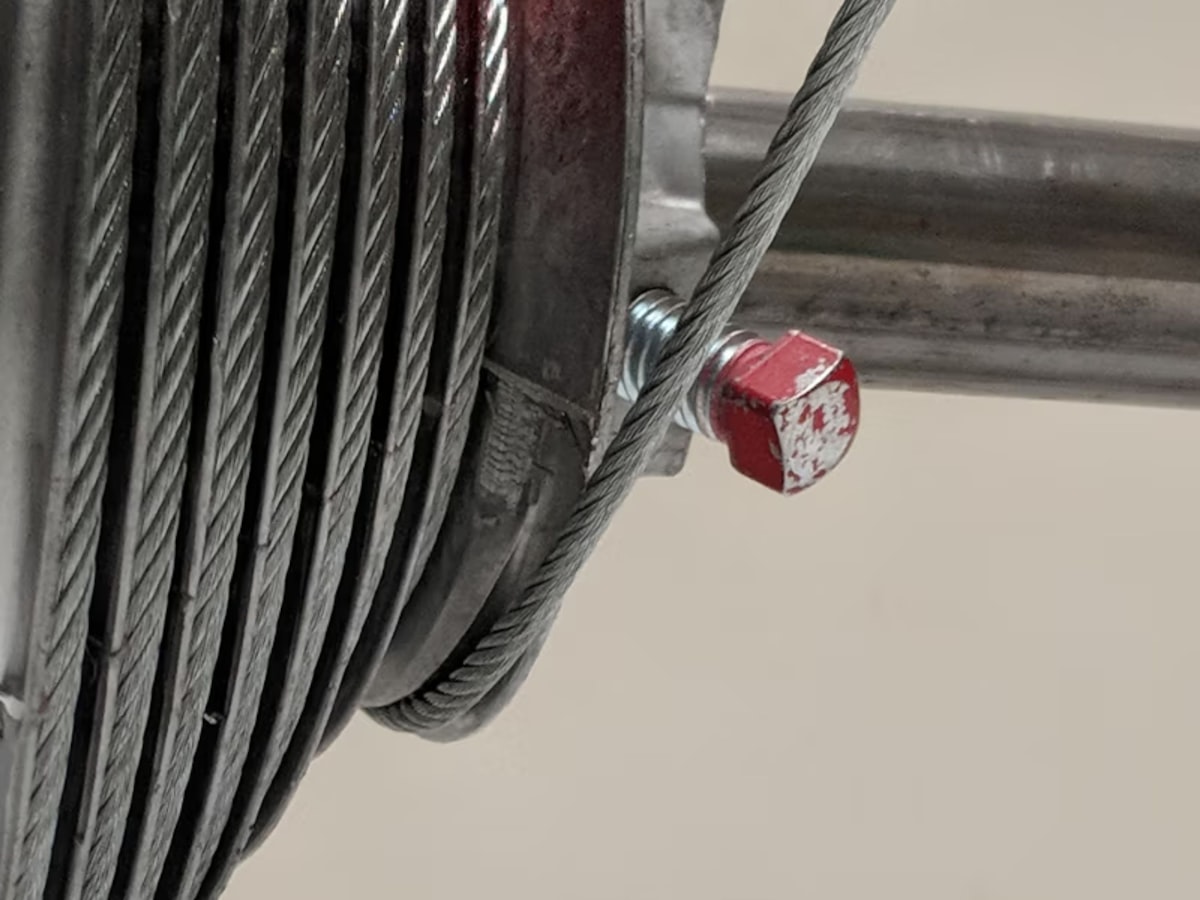 Close-up of a coiled cable and a red bolt