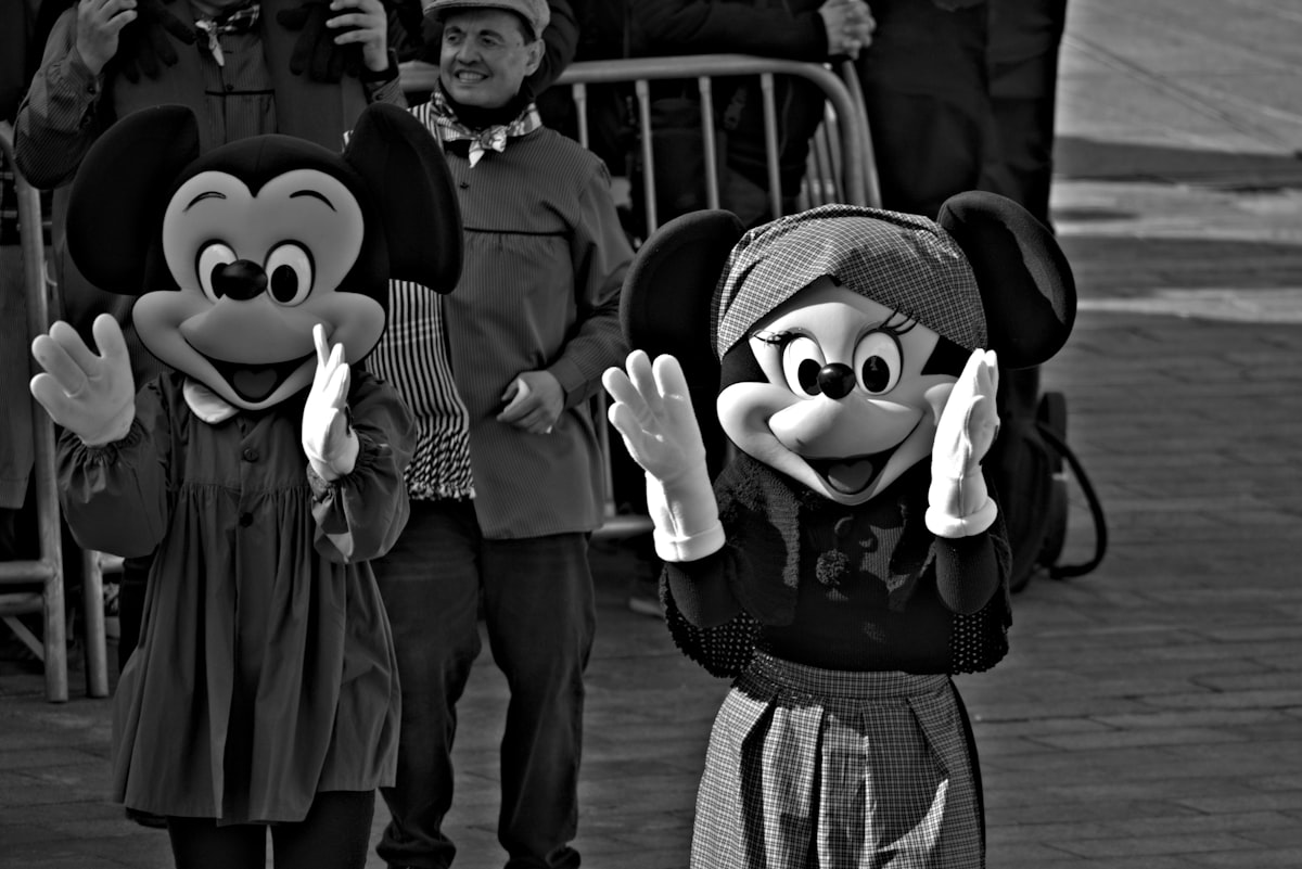 Minnie mouse characters wave at the crowd.