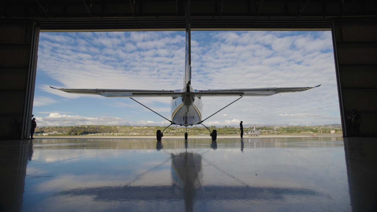 Tail of airplane in hangar reflecting on floor