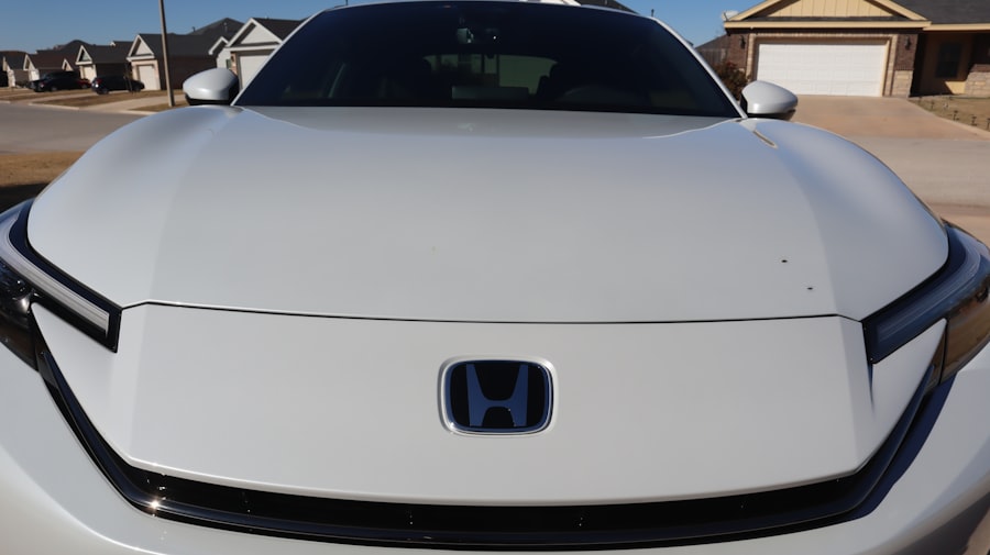 White car with blue honda logo on hood