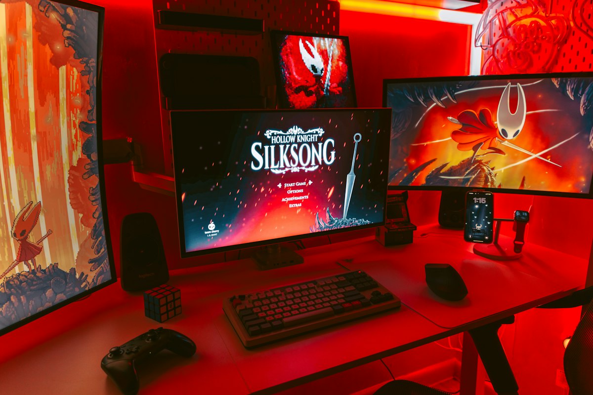 Gaming setup with multiple monitors displaying game art