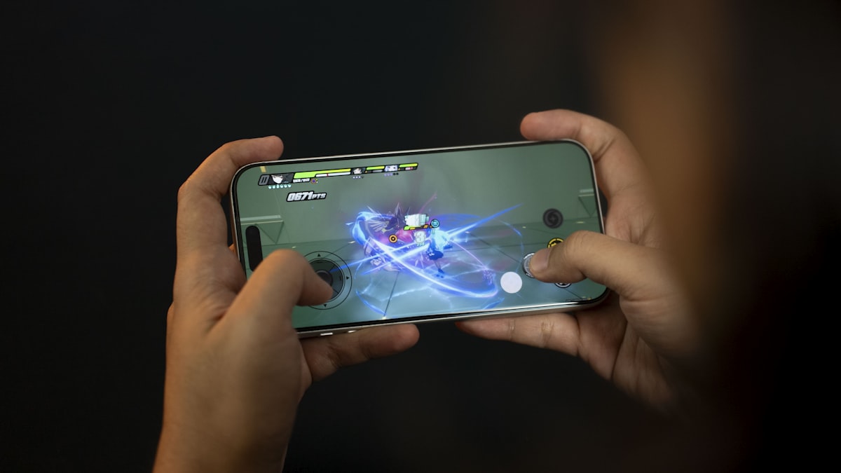 Hands holding a smartphone playing a video game.