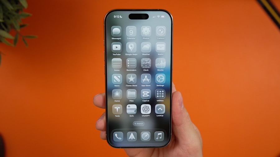 Hand holding a smartphone with a grid of icons.