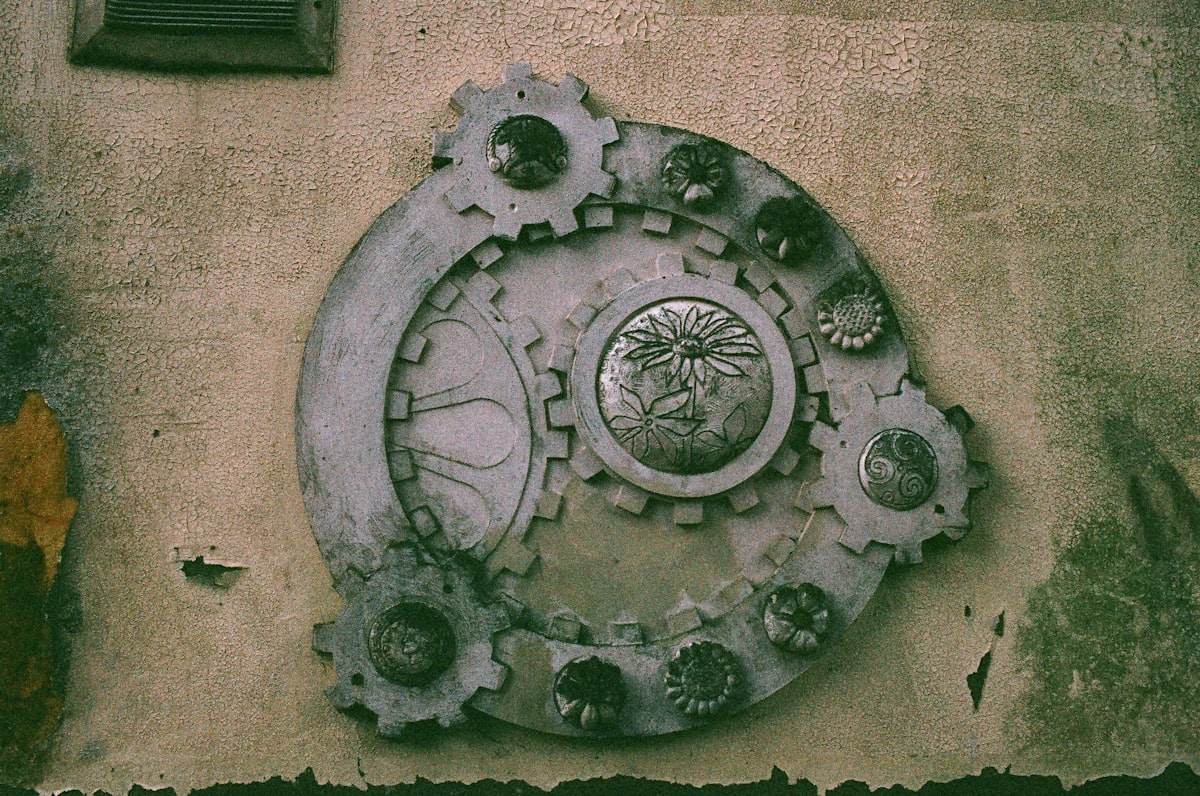 Ornate metal gearwork decoration on a textured wall