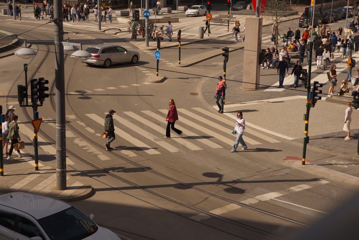 a group of people walking across a street