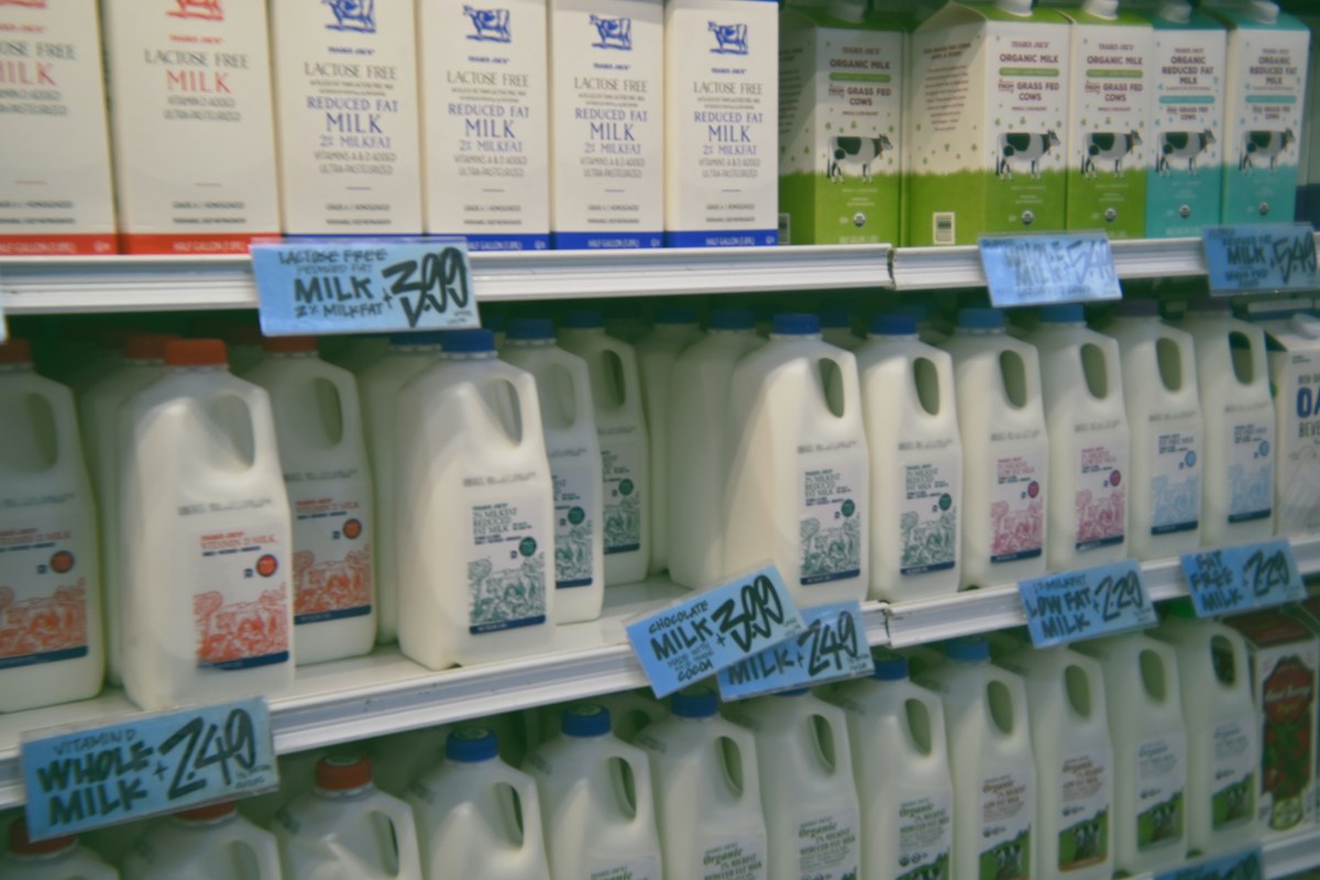 A store shelf filled with lots of milk