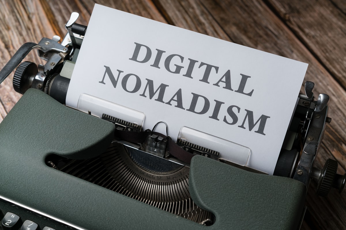 a close up of a typewriter with a paper that reads digital nomadism