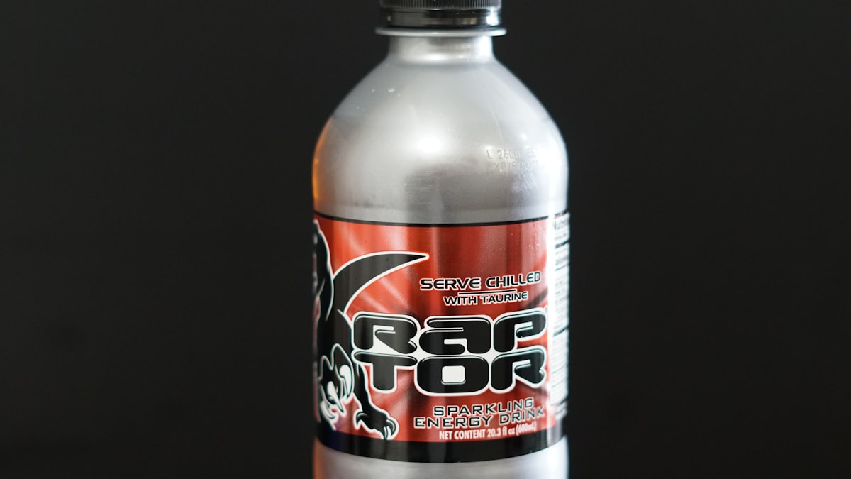A silver bottle with a red and black label.